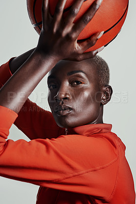 Buy stock photo Studio shot of an attractive young woman playing basketball against a grey background