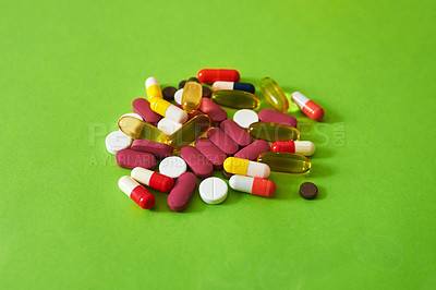 Buy stock photo Studio shot of a pile of different tablets against a green background