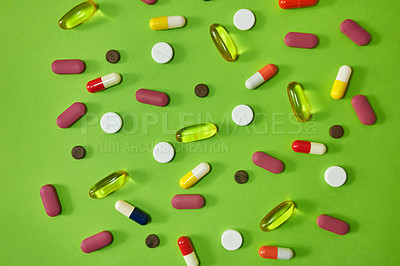 Buy stock photo Studio shot of an assortment of medication against a green background