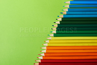 Buy stock photo Studio shot of different coloured pencils against a green background