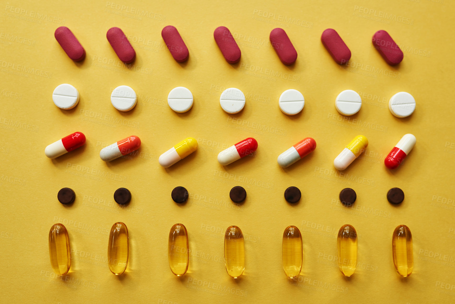 Buy stock photo Studio shot of an assortment of medication against a yellow background