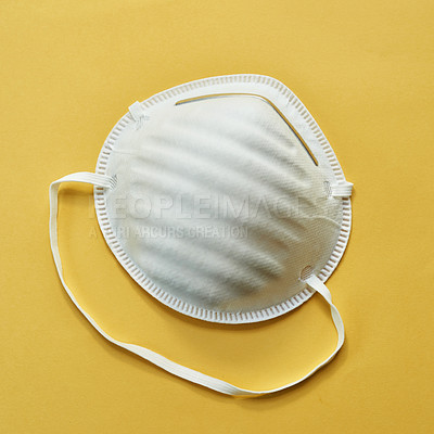 Buy stock photo Studio shot of a protective face mask against a yellow background