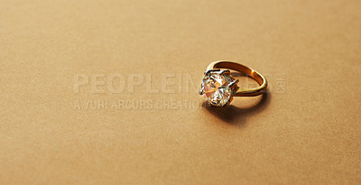Buy stock photo Studio shot of a gold ring with a diamond against a brown background
