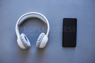 Buy stock photo Studio shot of a pair of headphones and smartphone against a grey background