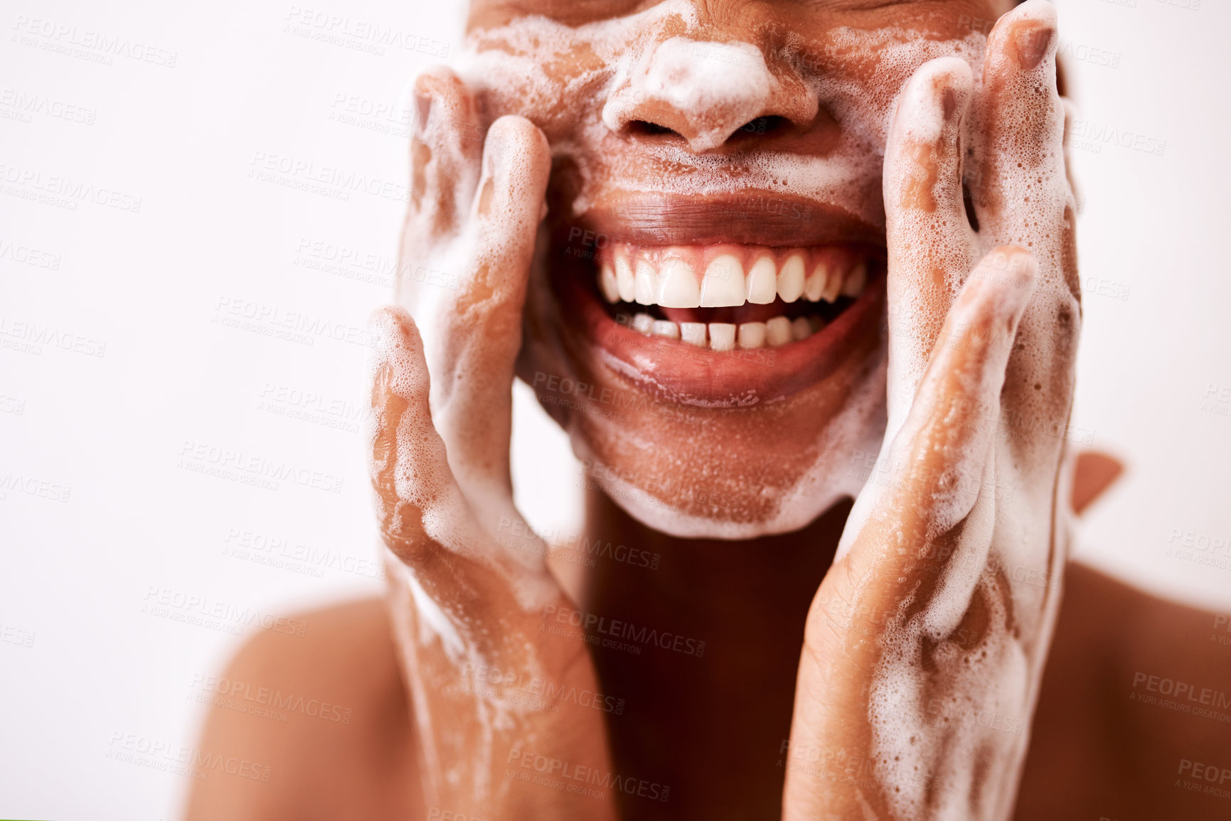 Buy stock photo Studio shot of an unrecognizable woman washing her face against a white background