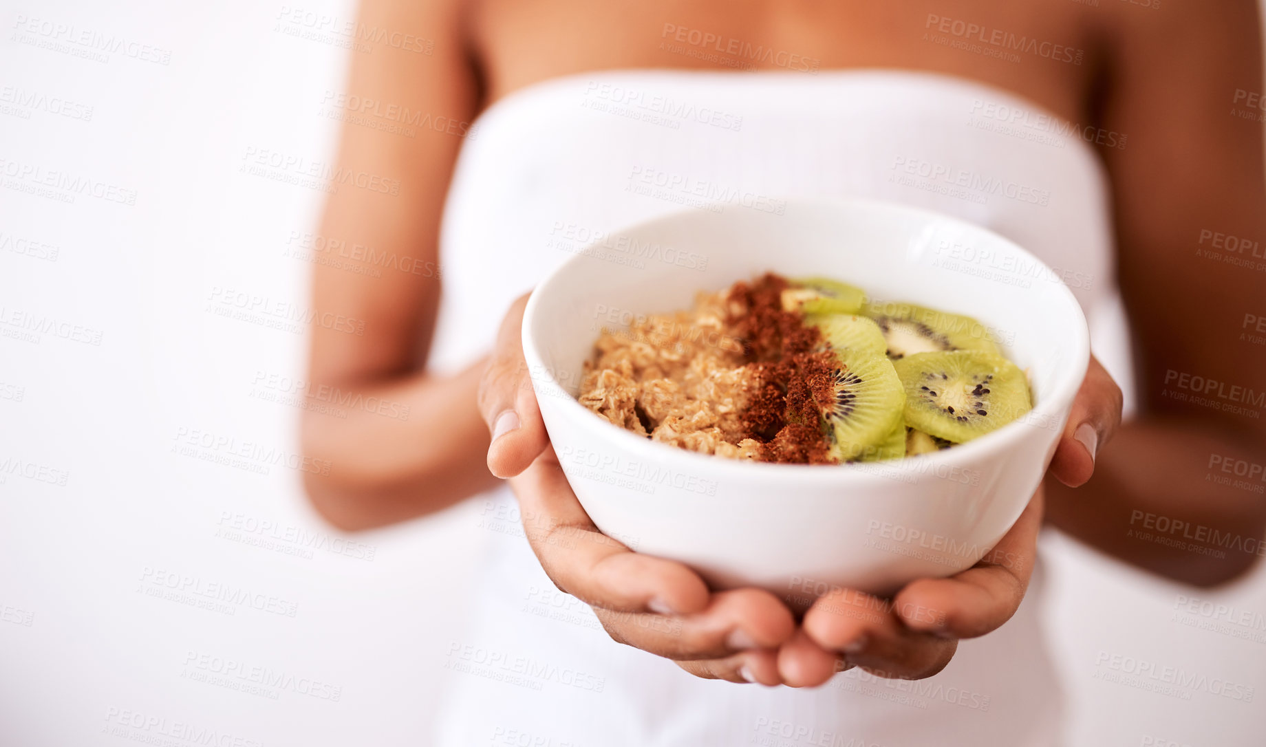 Buy stock photo Studio shot of an unrecognizable woman holding a bowl with oats and kiwi fruit