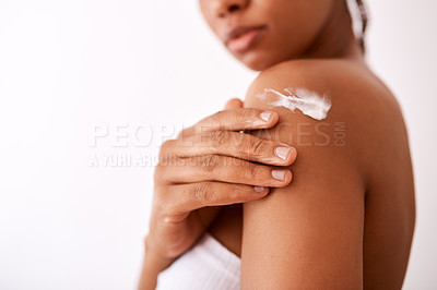 Buy stock photo Studio shot of an unrecognizable woman putting moisturiser on her body