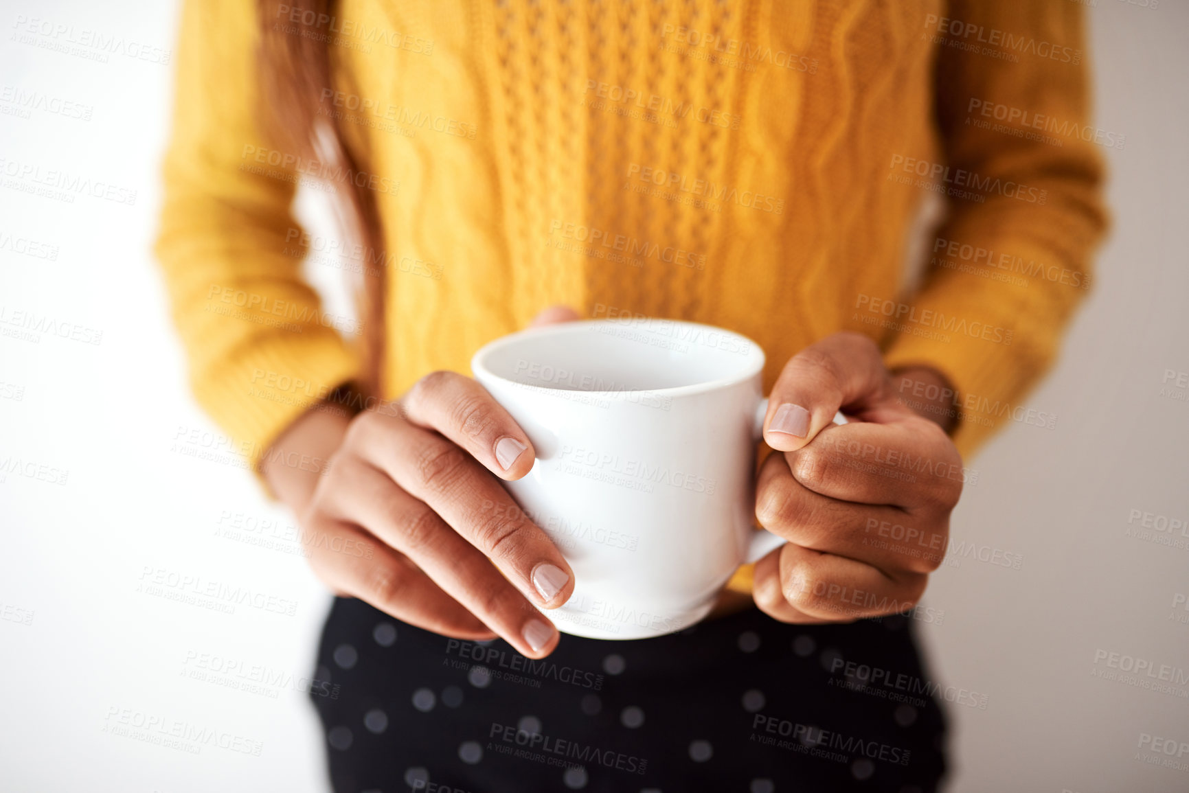 Buy stock photo Cropped shot of an unrecognizable woman holding a cup of coffee