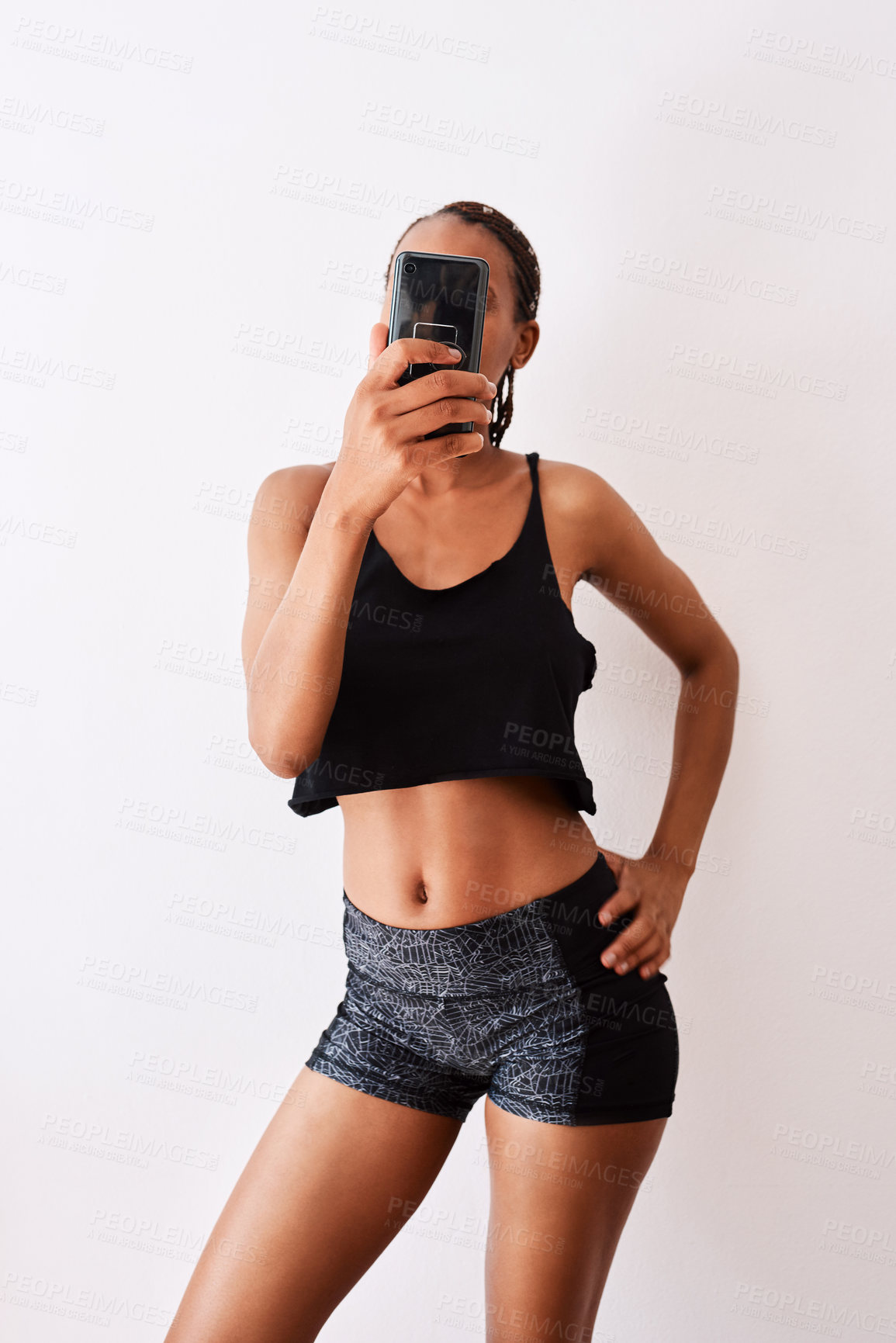 Buy stock photo Studio shot of a young woman taking a selfie while wearing her gym clothes