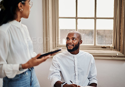 Buy stock photo Shot of a young businessman and businesswoman using a digital tablet during a meeting in a modern office