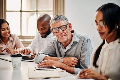 Buy stock photo Portrait of a mature businessman having a meeting with colleagues in a modern office
