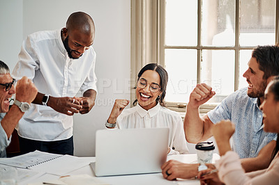 Buy stock photo Shot of a group of businesspeople cheering while using a laptop during a meeting in a modern office