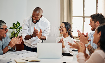 Buy stock photo Shot of a group of businesspeople clapping while using a laptop during a meeting in a modern office