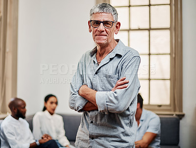 Buy stock photo Portrait of a mature businessman working in a modern office with his colleagues in the background