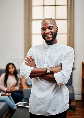 Buy stock photo Portrait of a young businessman working in a modern office with his colleagues in the background
