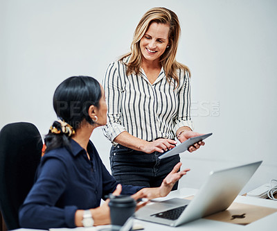 Buy stock photo Cropped shot of an attractive businesswoman helping a female colleague in the office