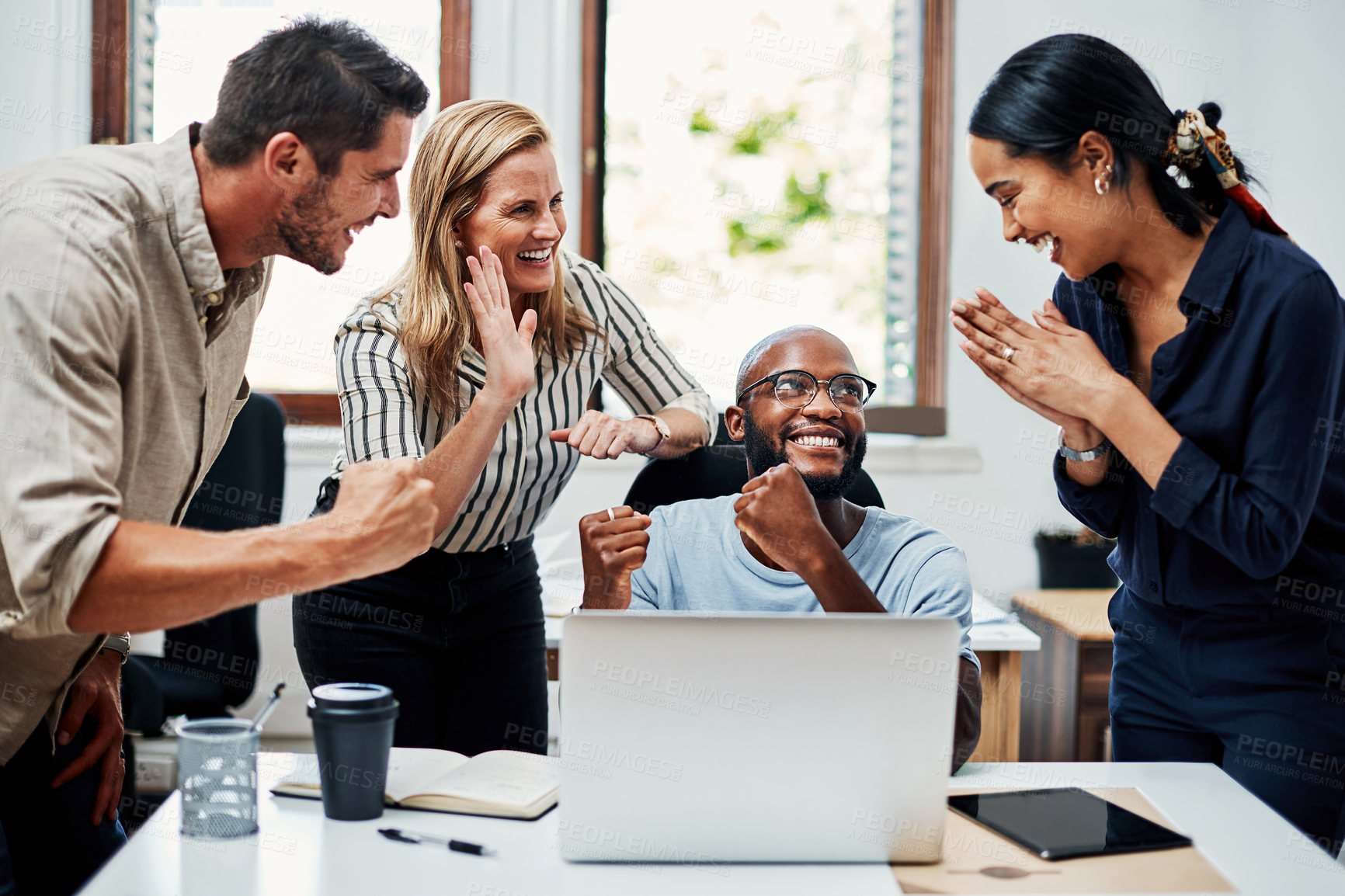 Buy stock photo Cropped shot of a group of business colleagues cheering while gathered around a laptop in the office