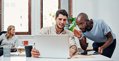 Buy stock photo Cropped shot of a handsome young businessman helping a male colleague in the office