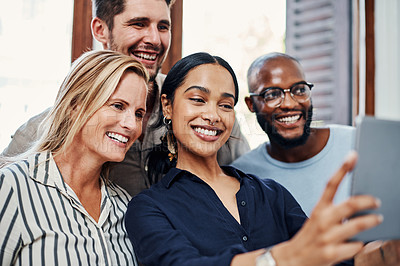 Buy stock photo Cropped shot of a group of business colleagues taking selfies with a tablet in the office