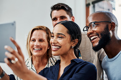 Buy stock photo Cropped shot of a group of business colleagues taking selfies with a tablet in the office