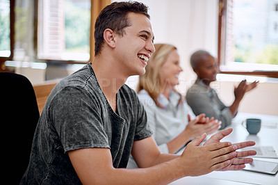 Buy stock photo Shot of a young businessman applauding during a presentation in an office
