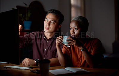 Buy stock photo Shot of two businesspeople working on a computer in an office at night
