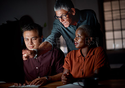 Buy stock photo Shot of a group of businesspeople working on a computer in an office at night