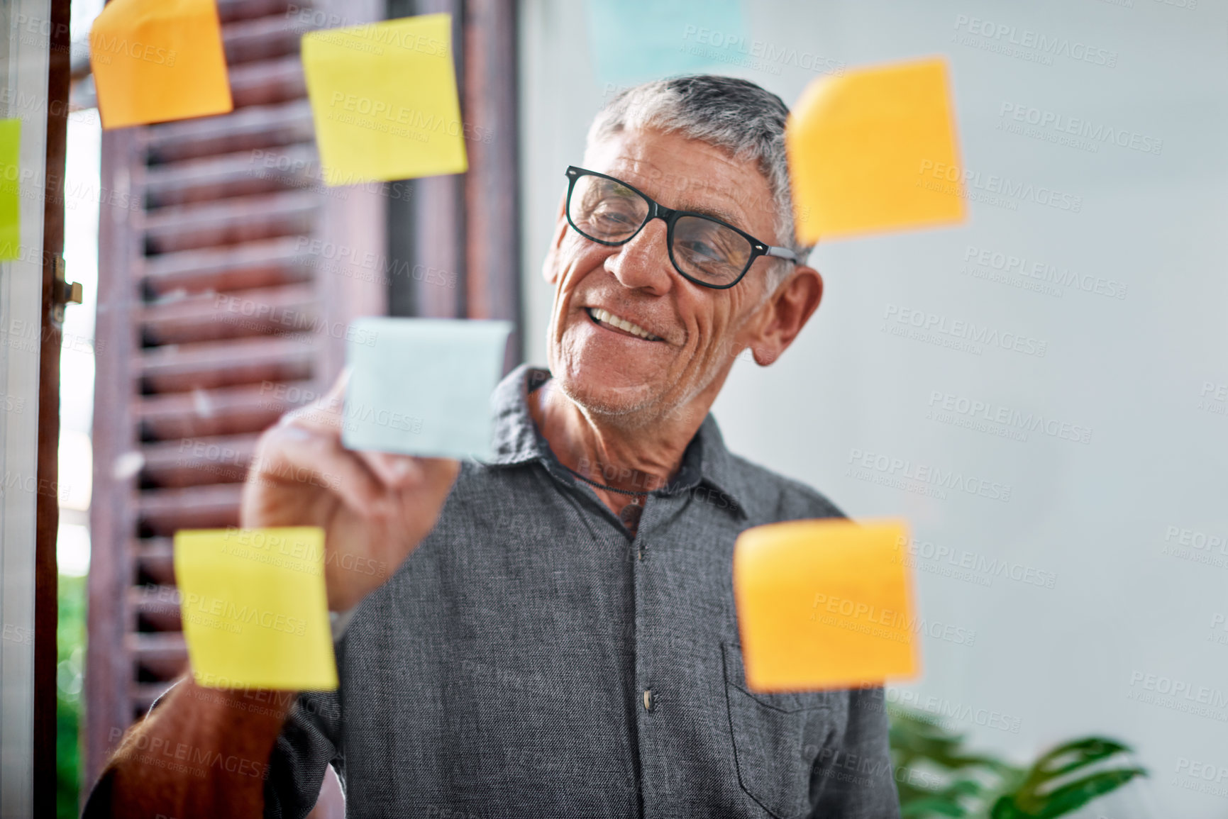 Buy stock photo Sticky note, planning or mature business man in office for brainstorming idea at creative startup. Glass wall, smile or manager with paper for schedule, mind map or software developer problem solving