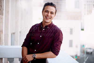 Buy stock photo Portrait of a young businessman standing outside on the balcony of an office