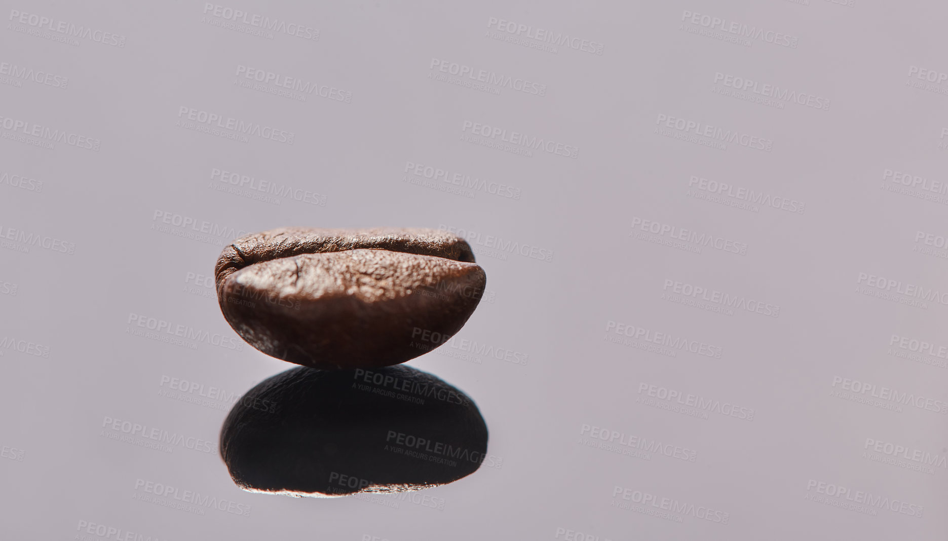 Buy stock photo Studio shot of a coffee bean lying on a grey tabletop