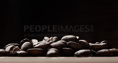 Buy stock photo Still life shot of coffee beans on a wooden countertop against a black background