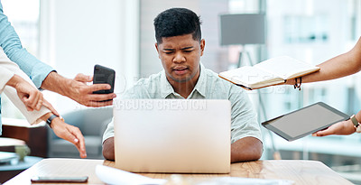Buy stock photo Shot of a young businessman looking stressed out in a demanding office environment