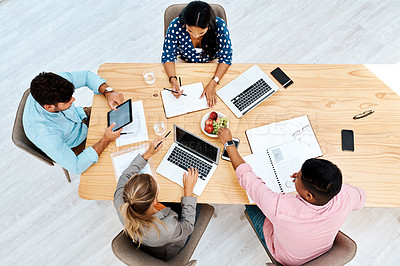 Buy stock photo High angle shot of a group of businesspeople working together at a table in an office