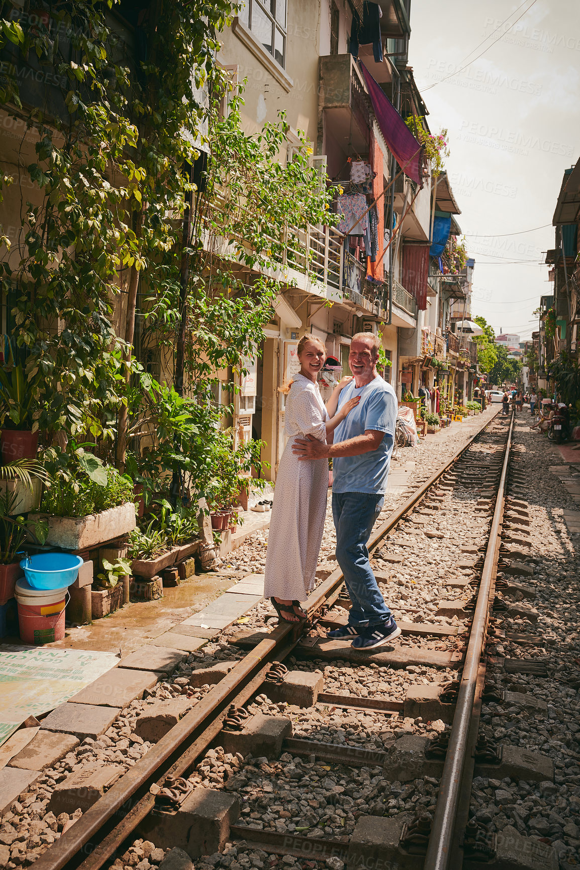 Buy stock photo Travel, couple and happy in portrait on train track for holiday adventure, hugging and sightseeing Vietnam. Tourist, mature man and exploring destination for vacation, romance or getaway with bonding