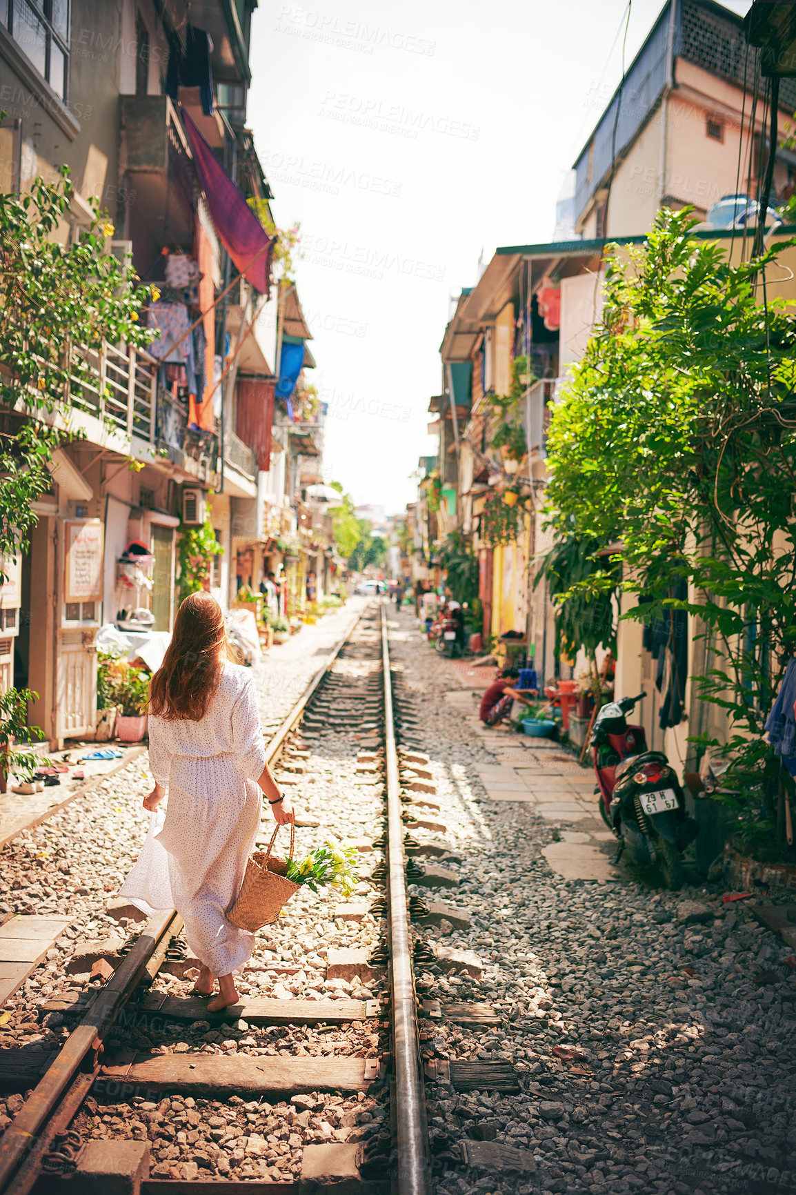 Buy stock photo City, walking and back of woman on train tracks for holiday, vacation and adventure in Vietnam. Fashion, travel and person on railway for journey, tourist destination and sightseeing in urban town