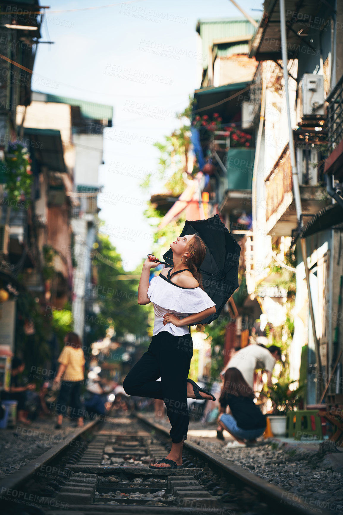 Buy stock photo Happy woman, umbrella and railway in city for adventure, explore and sightseeing with freedom. Female person, travel and excited on train track for holiday destination, vacation or outdoor in Vietnam