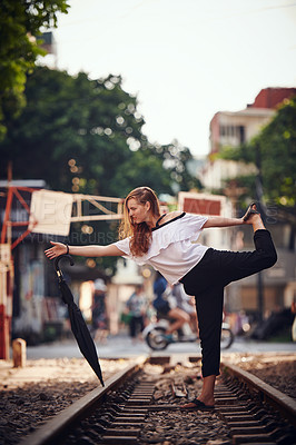 Buy stock photo Woman, travel and dancing on train track, outdoor and balance in city on vacation. Girl, person and umbrella on railway, playful and tourism with performance, profile and art in town in Germany