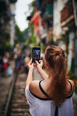 Buy stock photo Cropped shot of a young woman taking pictures while exploring a foreign city