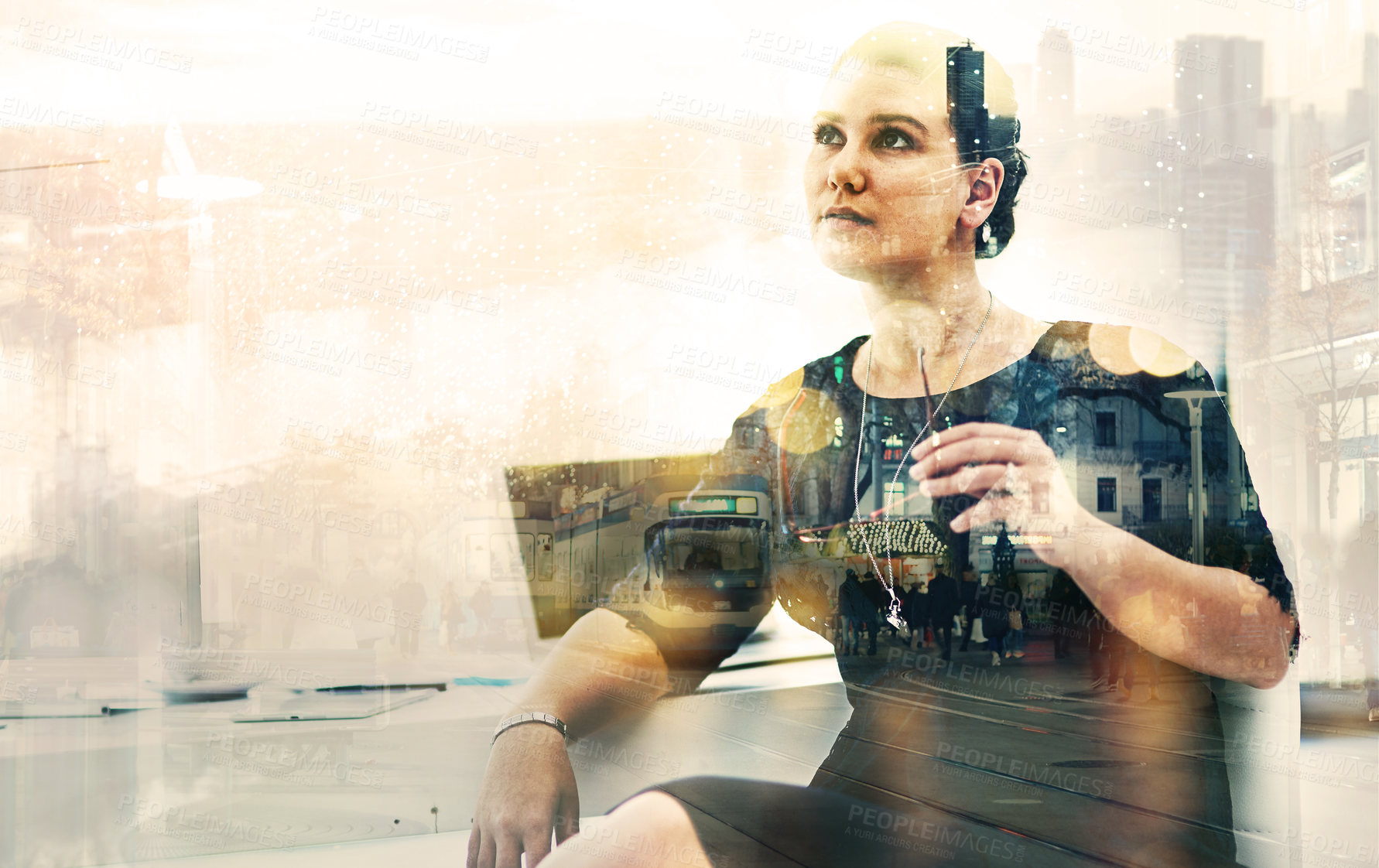 Buy stock photo Shot of a businesswoman sitting at her desk superimposed over a cityscape