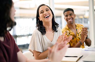 Buy stock photo Shot of a young businesswoman applauding while sitting alongside her colleagues during a presentation in an office