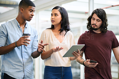 Buy stock photo Shot of a group of businesspeople having a discussion while walking through an office together