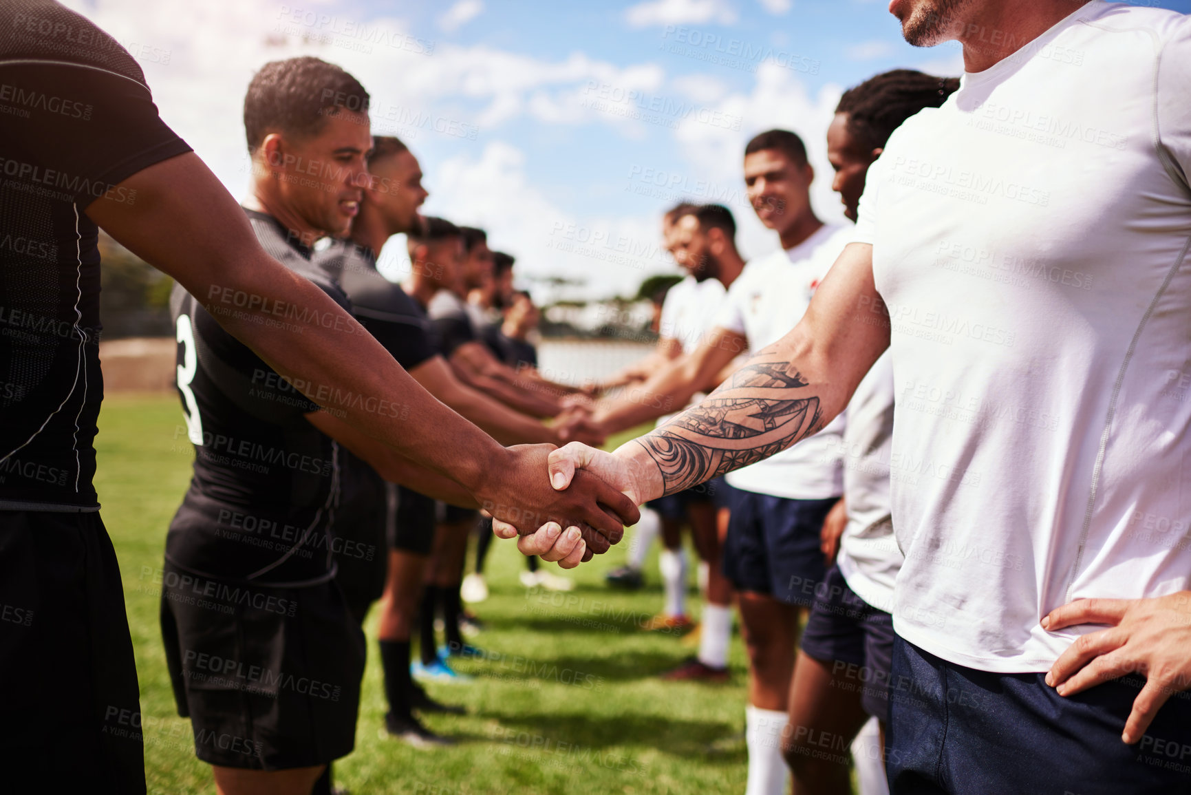 Buy stock photo Shot of a group of young rugby players shaking hands on the field