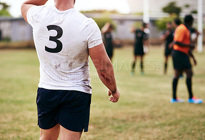 Buy stock photo Cropped shot of a man playing a game of rugby with his teammates in the background