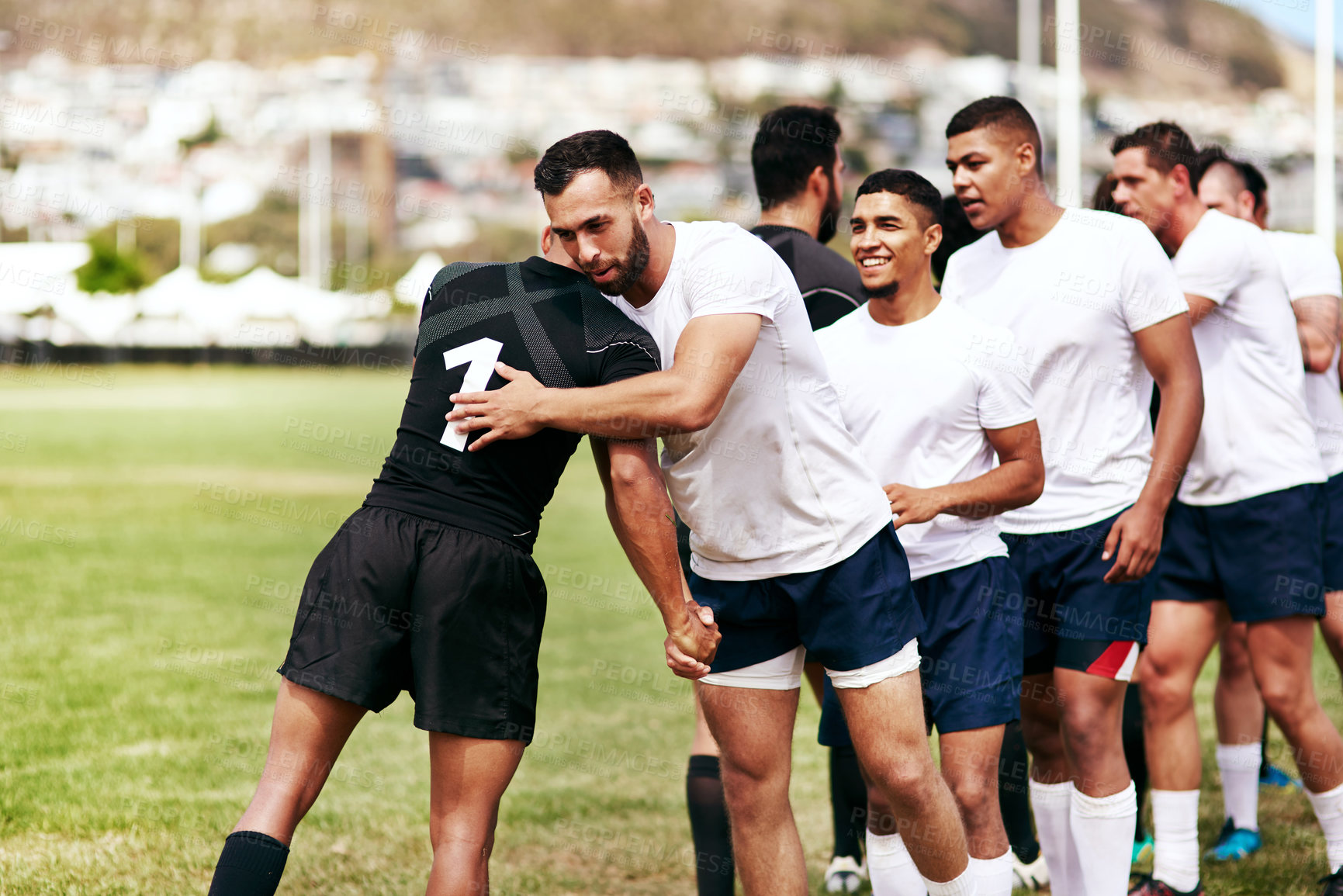 Buy stock photo Shot of a group of young men shaking hands during a game of rugby