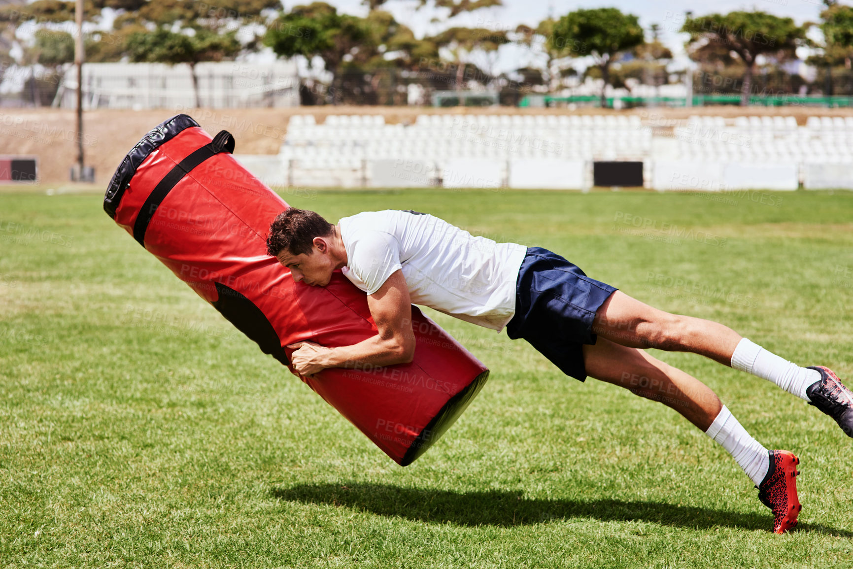 Buy stock photo Man, rugby and tackle bag at field for training as player with practice, fitness and workout in New Zealand. Male person, sports and stadium with strength on equipment as exercise for tournament