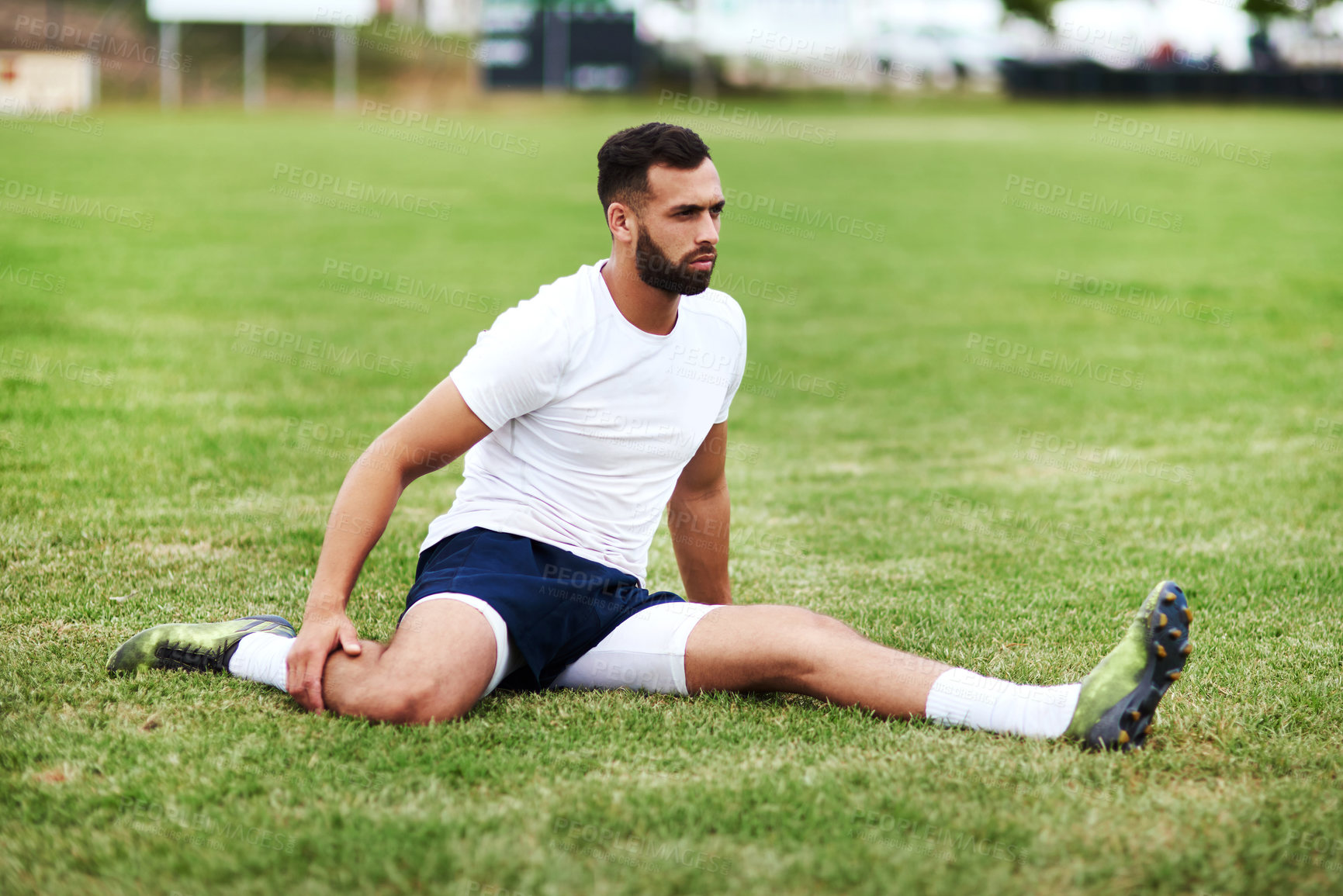 Buy stock photo Shot of a young man doing stretches on a rugby field