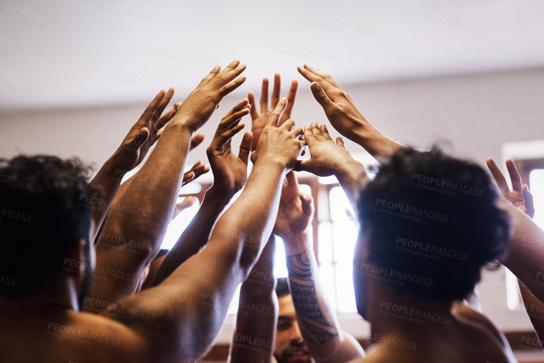 Buy stock photo Shot of a group of young rugby players joining their hands in solidarity in the locker room