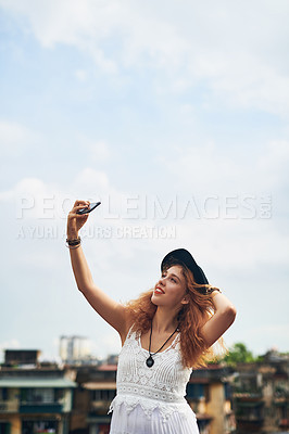 Buy stock photo Cropped shot of a young woman taking a selfie against a urban background