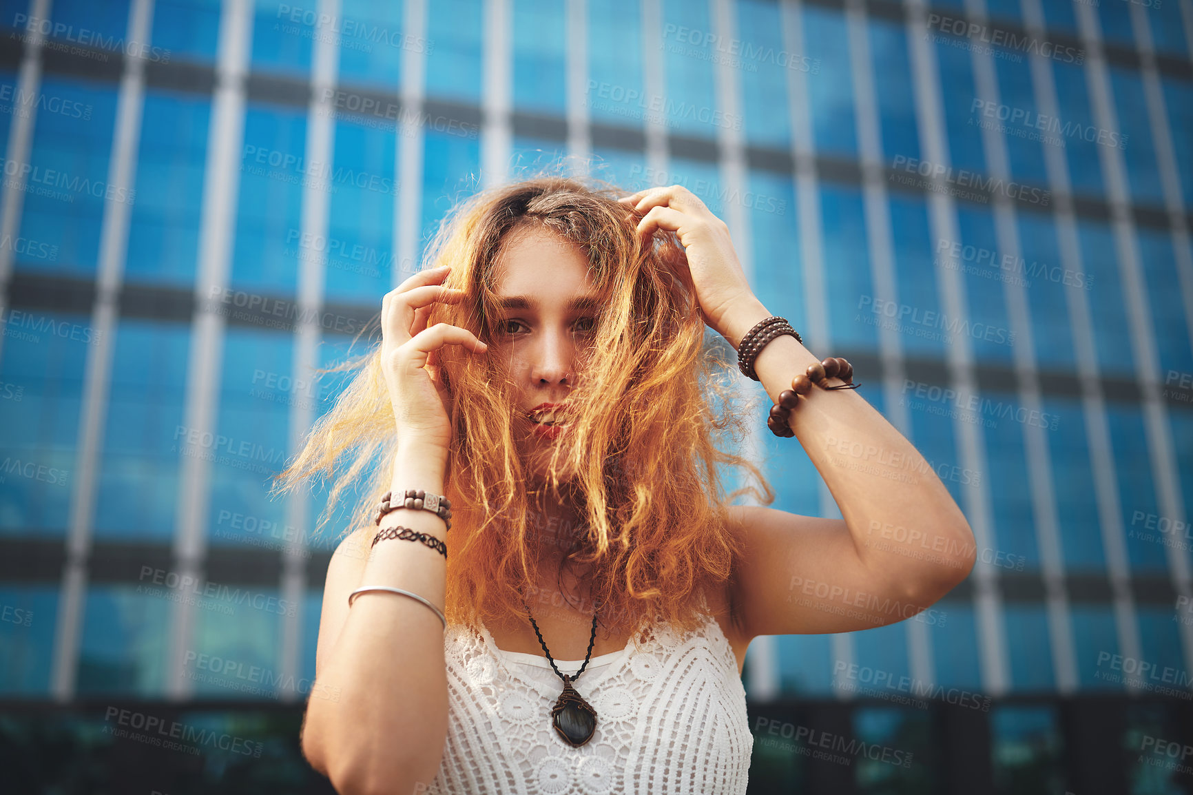 Buy stock photo Portrait, woman and hair in city for fashion, street style or confidence as musician for band on tour. Female person, trendy and outdoor with glass building, architecture and urban background in USA