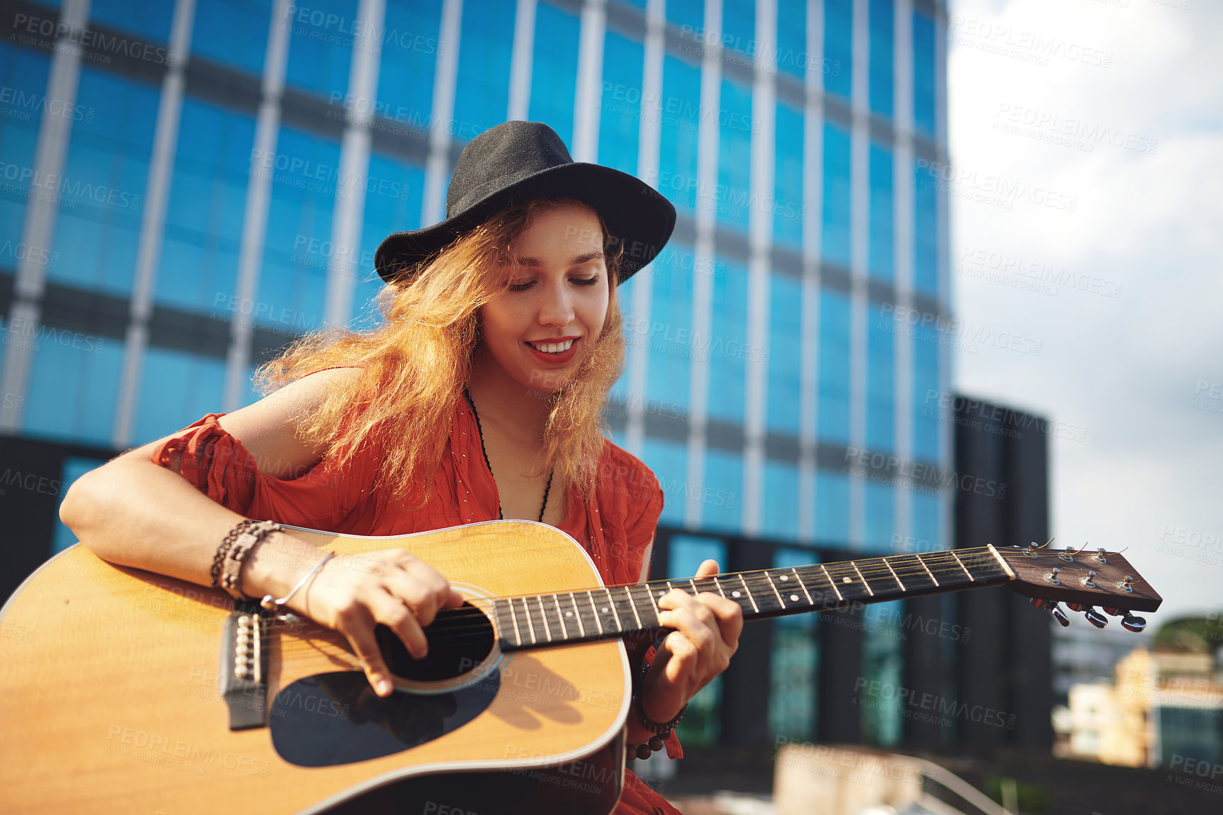 Buy stock photo Shot of a beautiful young woman out in the city with her guitar